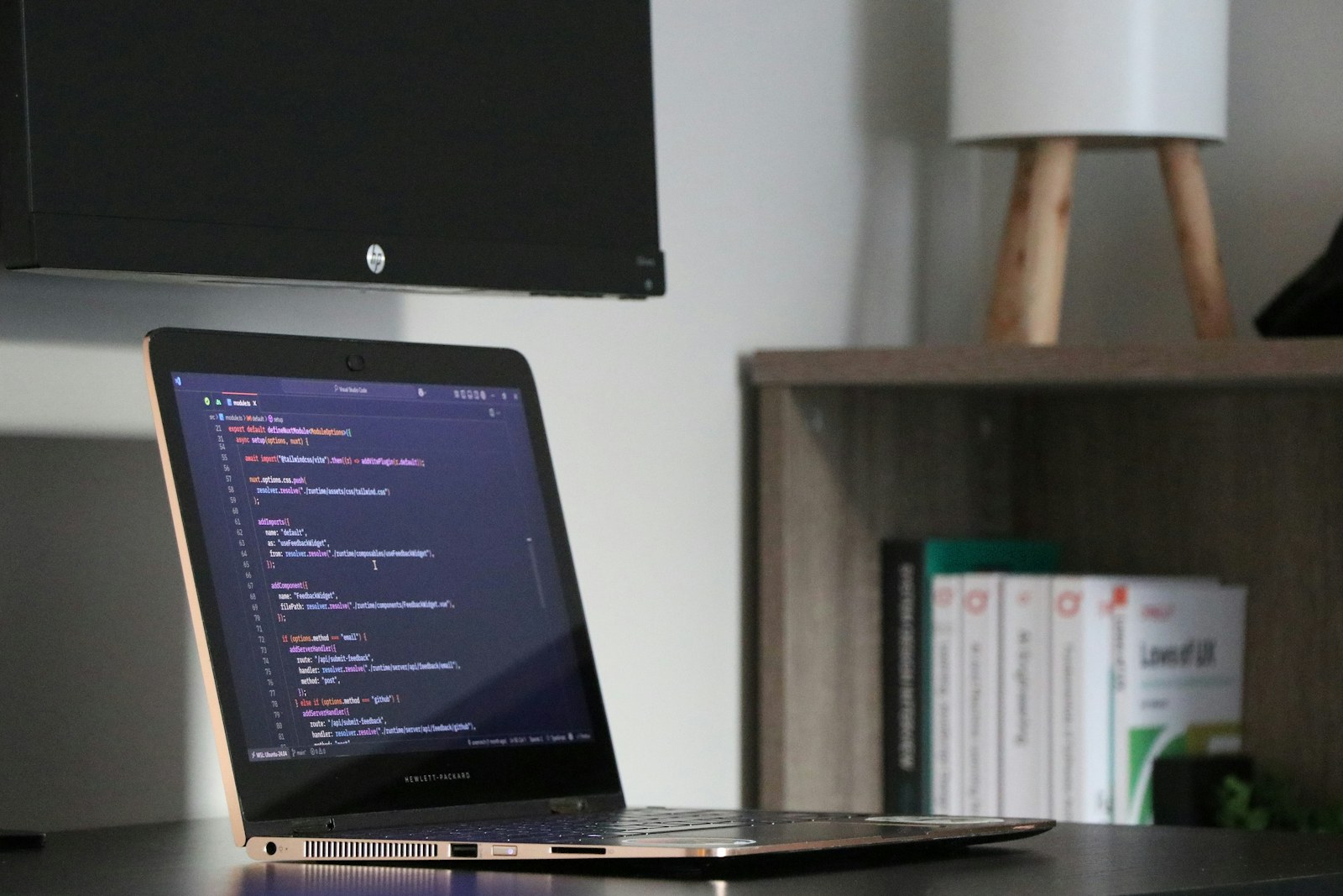 A laptop displaying application code at a software development workspace
