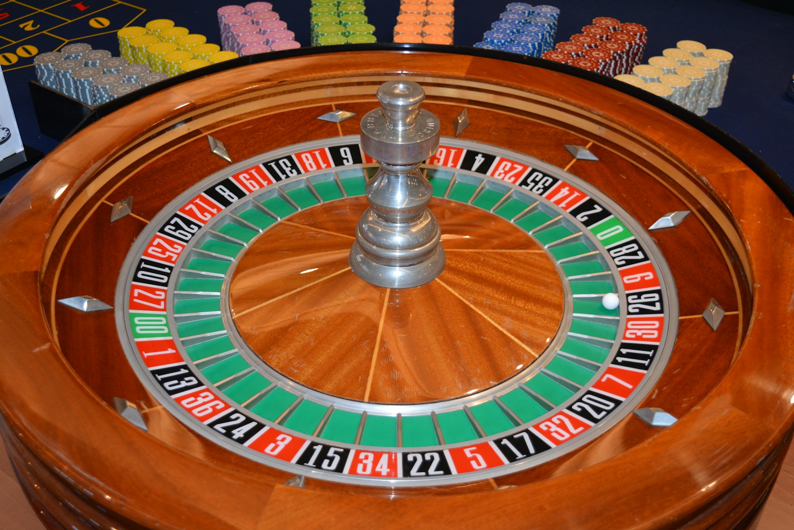 Roulette wheel and organized gaming chips on a casino table